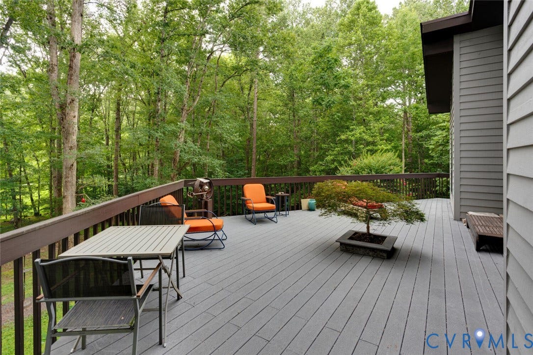 1474 Timber Ridge, Maidens, VA 23102 Expansive outdoor deck featuring wood-finish composite decking, a dark wood railing, and direct access to the home's gray horizontal cedar siding
