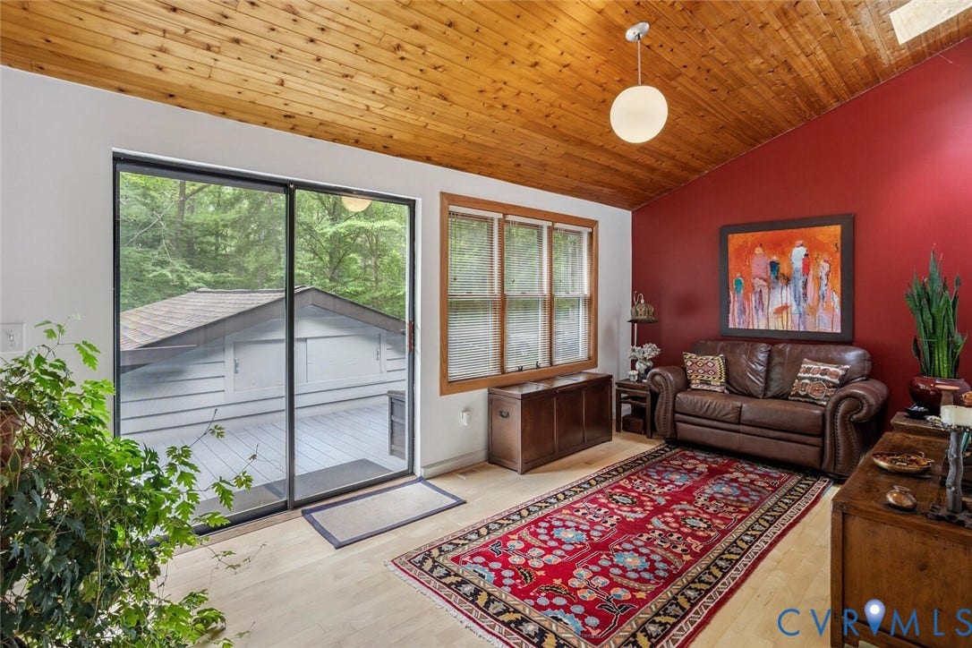 1474 Timber Ridge, Maidens, VA 23102 Yoga/Sitting room Vaulted wood-paneled ceiling with a spherical pendant light, wood-finish flooring, a full-height red accent wall, and a sliding glass door opening to an outdoor deck