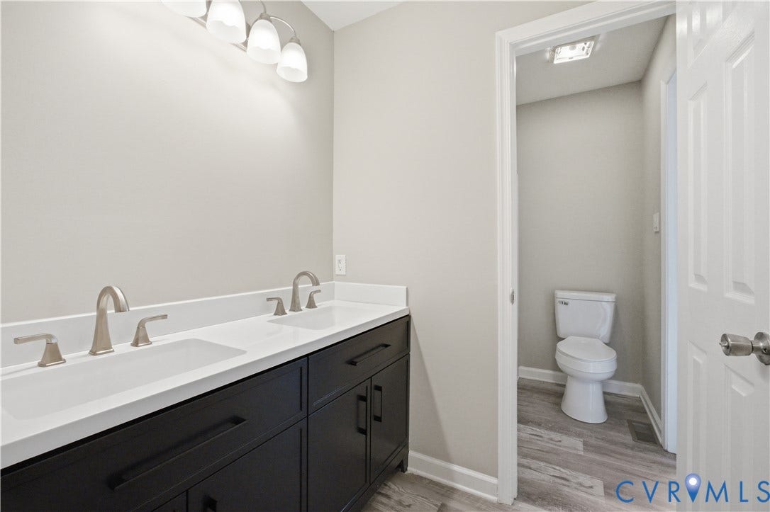 1304 Idlewood Avenue, Randolph, Richmond, VA 23220 Double vanity featuring integrated sinks, white countertops, dark cabinetry, and brushed nickel fixtures