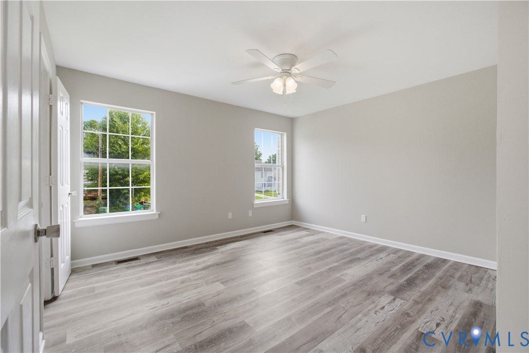 1304 Idlewood Avenue, Randolph, Richmond, VA 23220 Bright interior room with wood-finish flooring, two large windows, a ceiling fan, and light gray walls