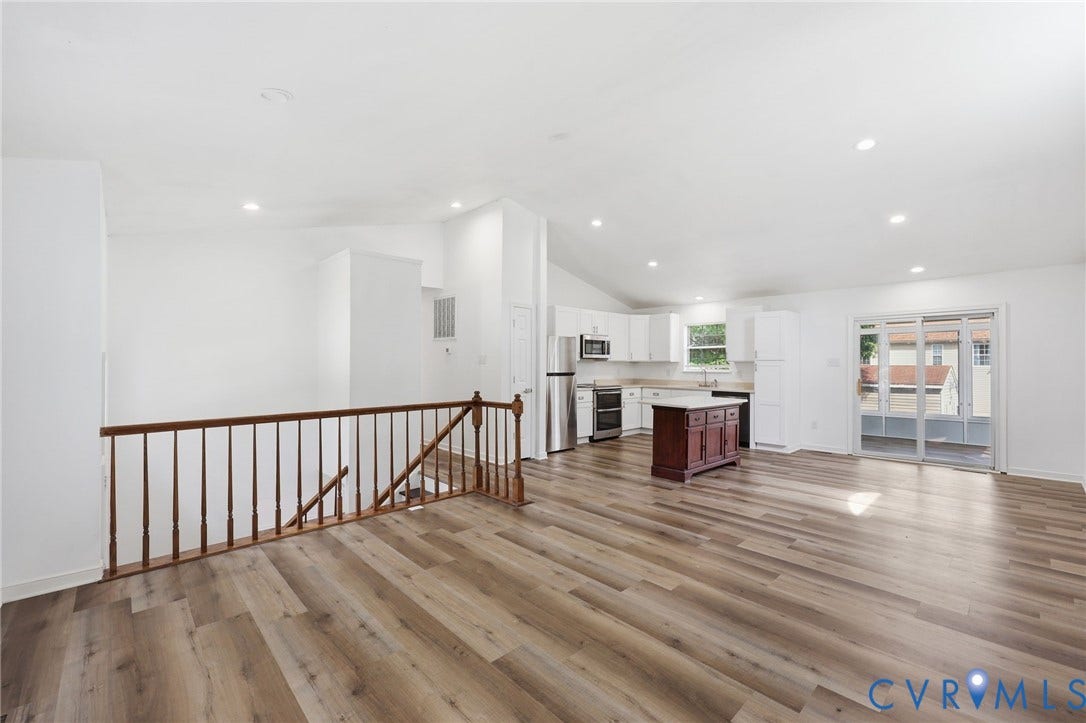 4217 Lipes Court, Glen Allen, VA 23223 Open-concept living space featuring wood-finish flooring, vaulted ceilings with recessed lighting, and a kitchen with white cabinetry and stainless steel appliances