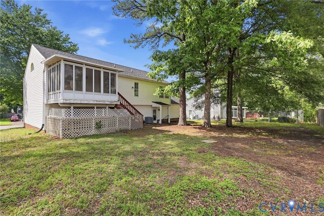 4217 Lipes Court, Glen Allen, VA 23223 Expansive rear yard featuring a screened porch, white siding exterior, red-stained exterior stairs, and mature trees