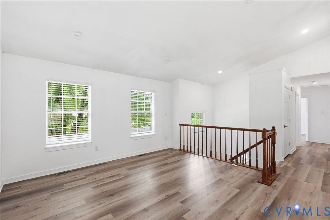 4217 Lipes Court, Glen Allen, VA 23223 Brightly lit interior space featuring wood-finish flooring, white walls, two double-hung windows with blinds, recessed ceiling lighting, and a wood railing