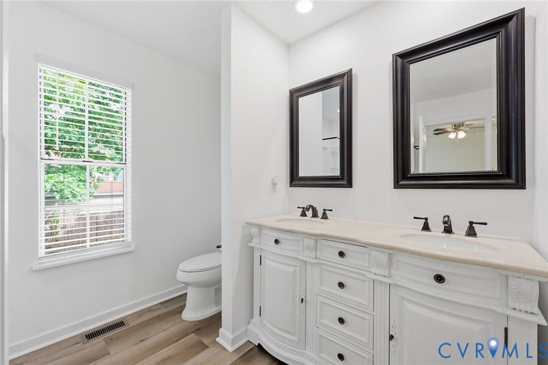 4217 Lipes Court, Glen Allen, VA 23223 Double vanity with integrated sinks, framed mirrors, wood-finish flooring, and a window with blinds