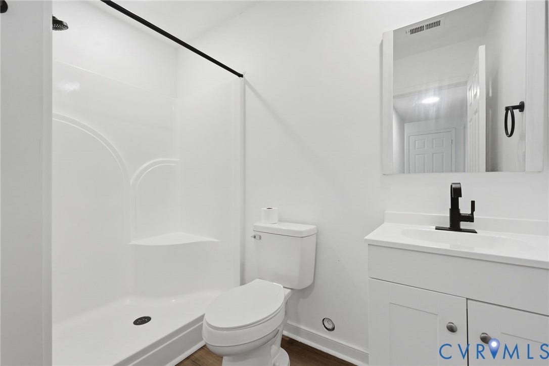 4217 Lipes Court, Glen Allen, VA 23223 Bathroom featuring a white shower stall with an integrated corner shelf, a white toilet, and a white vanity with a rectangular sink