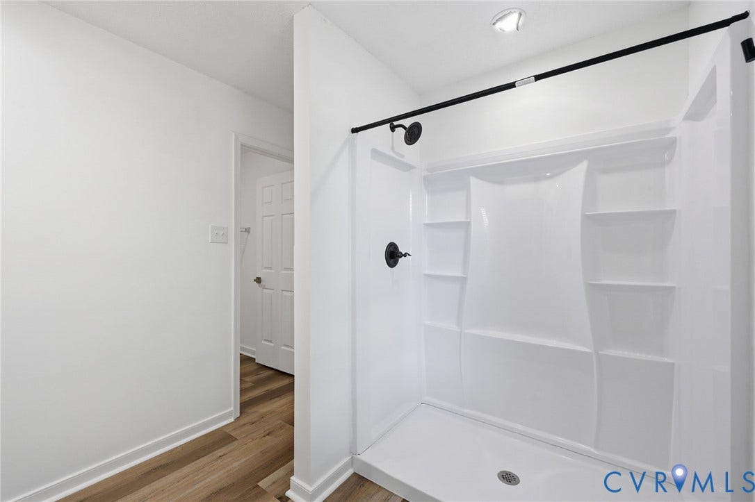 4217 Lipes Court, Glen Allen, VA 23223 Bright shower enclosure with matte black fixtures, integrated shelving, and a coordinating shower rod