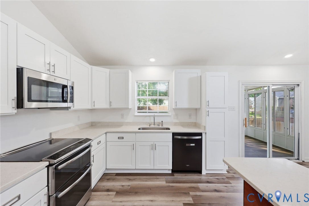 4217 Lipes Court, Glen Allen, VA 23223 Modern kitchen featuring white shaker cabinetry, light-toned countertops, stainless steel microwave, black electric range, and wood-finish flooring