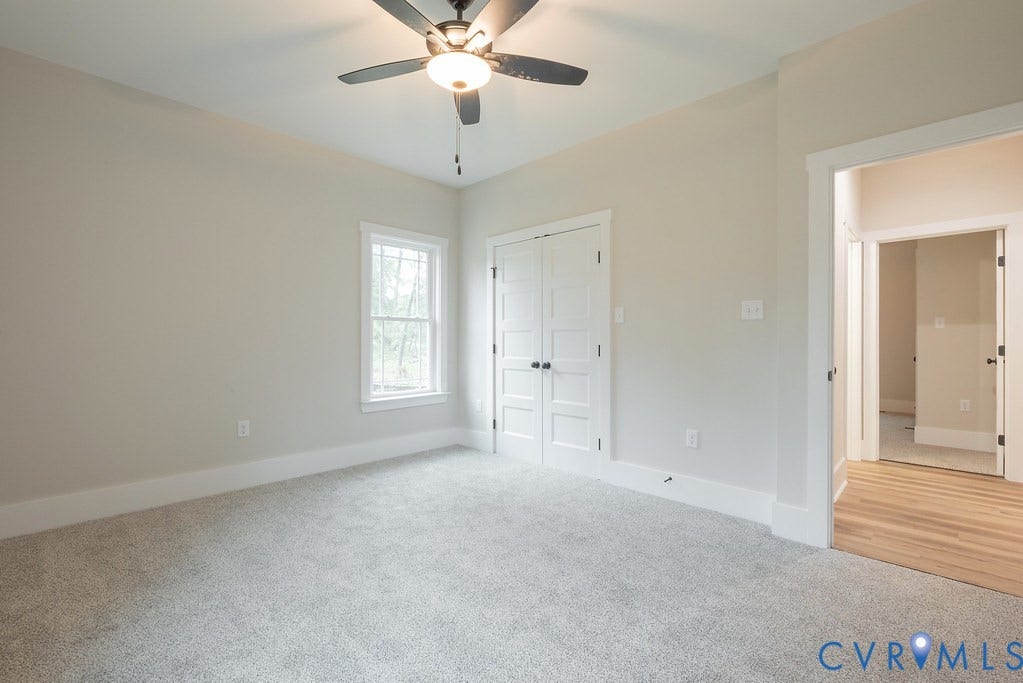 1220 Jefferson Highway, Moseley Estates, Louisa, VA 23093 Carpeted room featuring a ceiling fan with light fixture, double-pane window with white trim, and double white paneled doors
