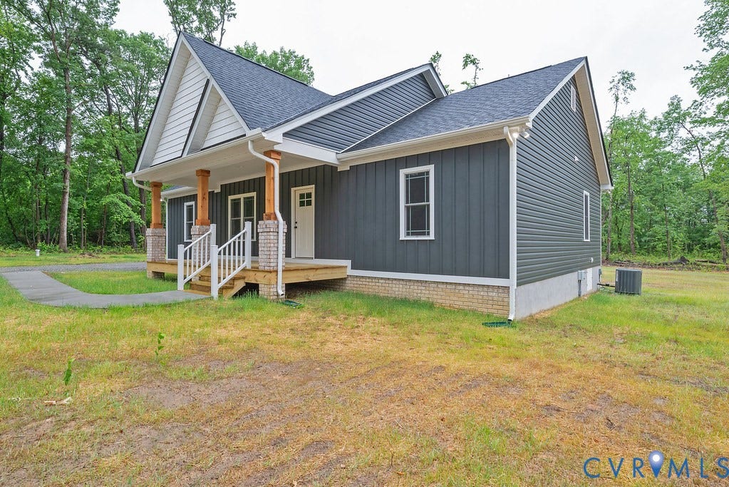 1220 Jefferson Highway, Moseley Estates, Louisa, VA 23093 Modern farmhouse exterior featuring dark gray vertical siding, a covered front porch with white railings, natural wood columns, and a dark shingle roof