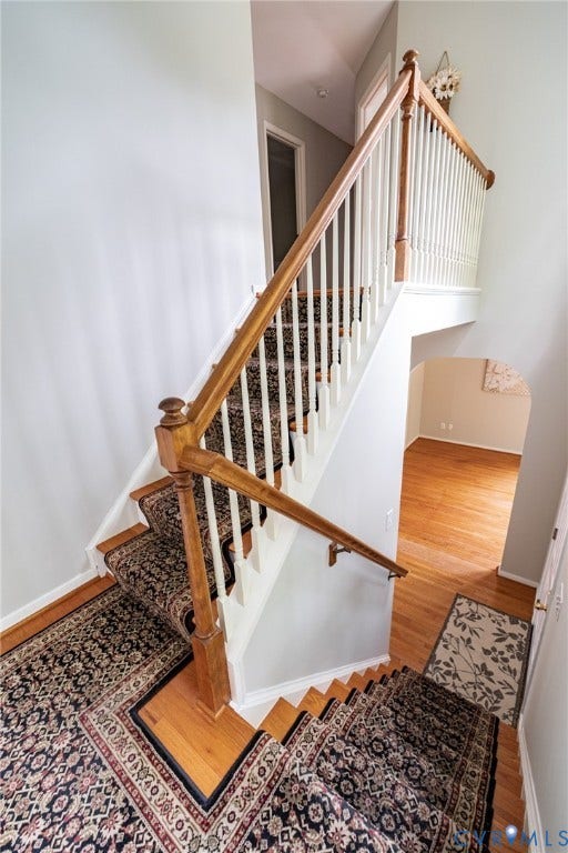 10517 Park Tree Place, Mountain Glen/ Glen Allen, Glen Allen, VA 23060 Staircase featuring wood-finish treads, patterned carpet runners, and a classic wood and white baluster railing