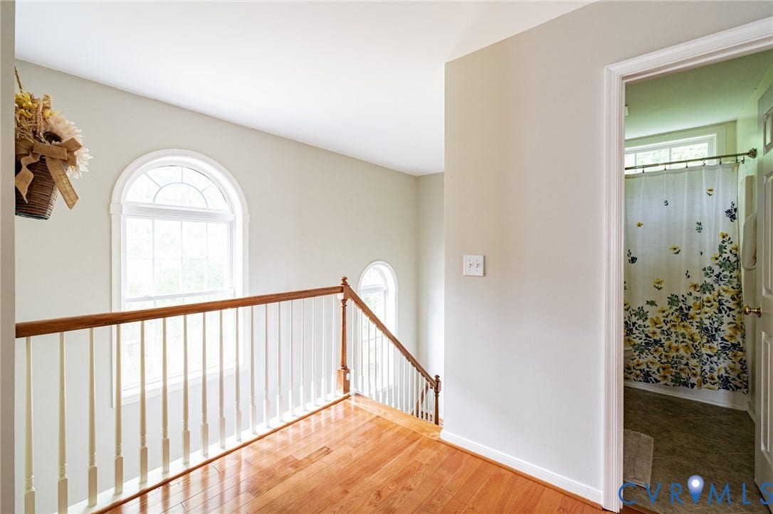 10517 Park Tree Place, Mountain Glen/ Glen Allen, Glen Allen, VA 23060 Upper-level landing featuring wood-finish flooring, white spindle railing with a wood handrail, and arched-top windows
