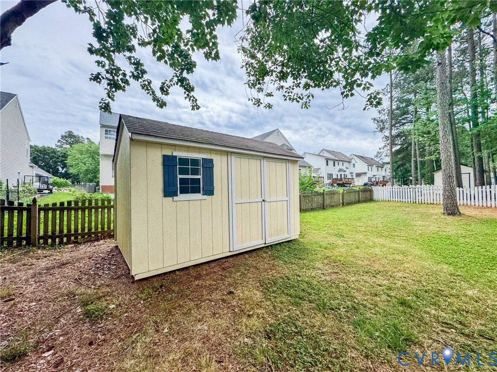 10517 Park Tree Place, Mountain Glen/ Glen Allen, Glen Allen, VA 23060 Detached storage shed featuring a neutral-toned exterior, a shingle roof, a window with blue shutters, and double entry doors