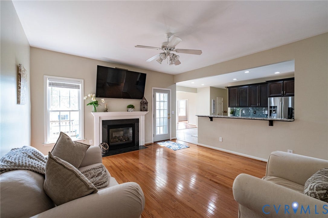 10517 Park Tree Place, Mountain Glen/ Glen Allen, Glen Allen, VA 23060 Living area featuring wood-finish flooring, a white mantel fireplace with a black surround, and a ceiling fan