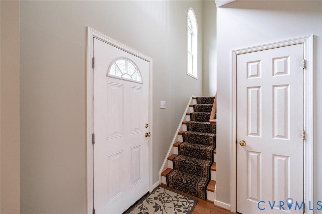 10517 Park Tree Place, Mountain Glen/ Glen Allen, Glen Allen, VA 23060 Entryway featuring a white paneled door with an arched transom, light gray walls, wood stairs with patterned carpet runner, and a brass door knob