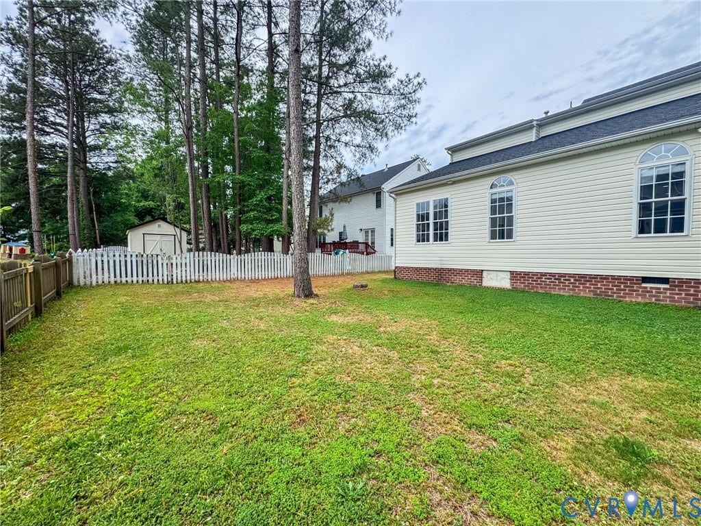 10517 Park Tree Place, Mountain Glen/ Glen Allen, Glen Allen, VA 23060 Expansive backyard featuring a manicured lawn, a white picket fence, a dedicated storage shed, and mature perimeter trees