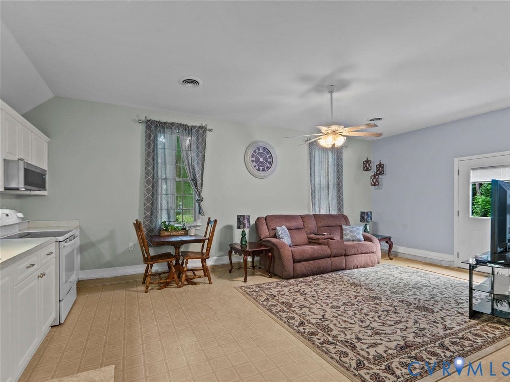 3420 Goodwyn Road, Powhatan, VA 23139 Flex-space open-concept room featuring a kitchen area with white cabinetry, light-colored countertops, and a built-in microwave