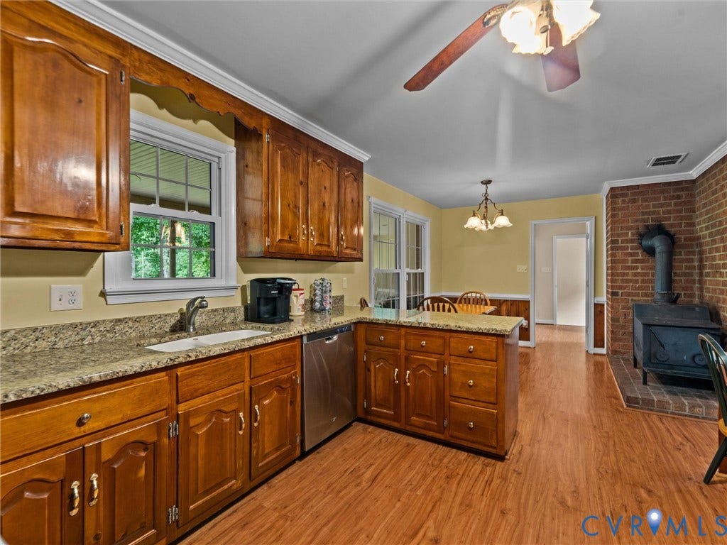 3420 Goodwyn Road, Powhatan, VA 23139 Kitchen featuring wood-finish cabinetry, light-toned countertops, a stainless steel dishwasher, and wood-finish flooring