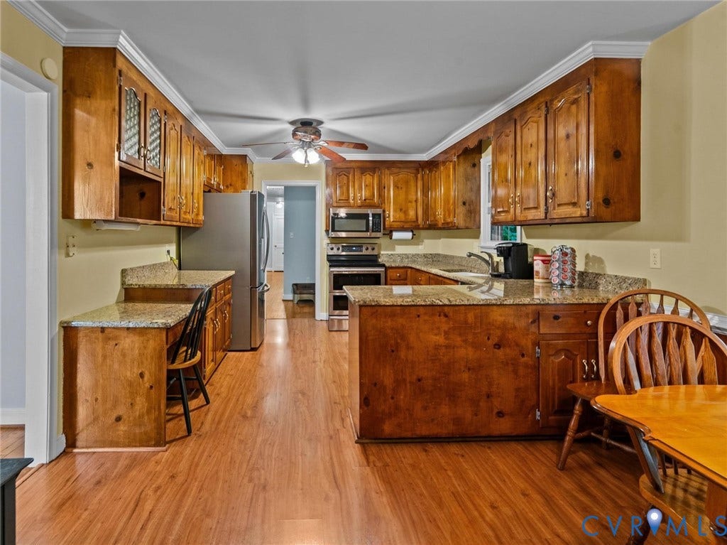 3420 Goodwyn Road, Powhatan, VA 23139 Kitchen featuring wood-finish flooring, natural wood cabinetry, light-toned countertops, and stainless steel appliances