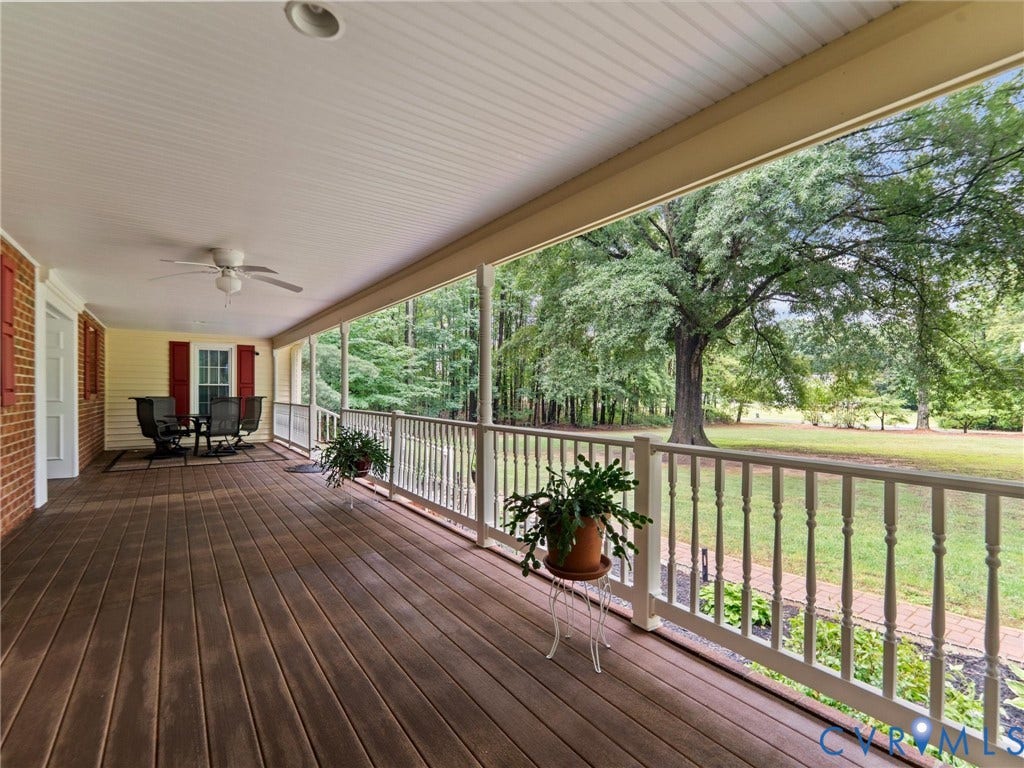 3420 Goodwyn Road, Powhatan, VA 23139 Expansive covered porch featuring wood-finish decking, white baluster railings, and a beadboard ceiling with a recessed light and ceiling fan