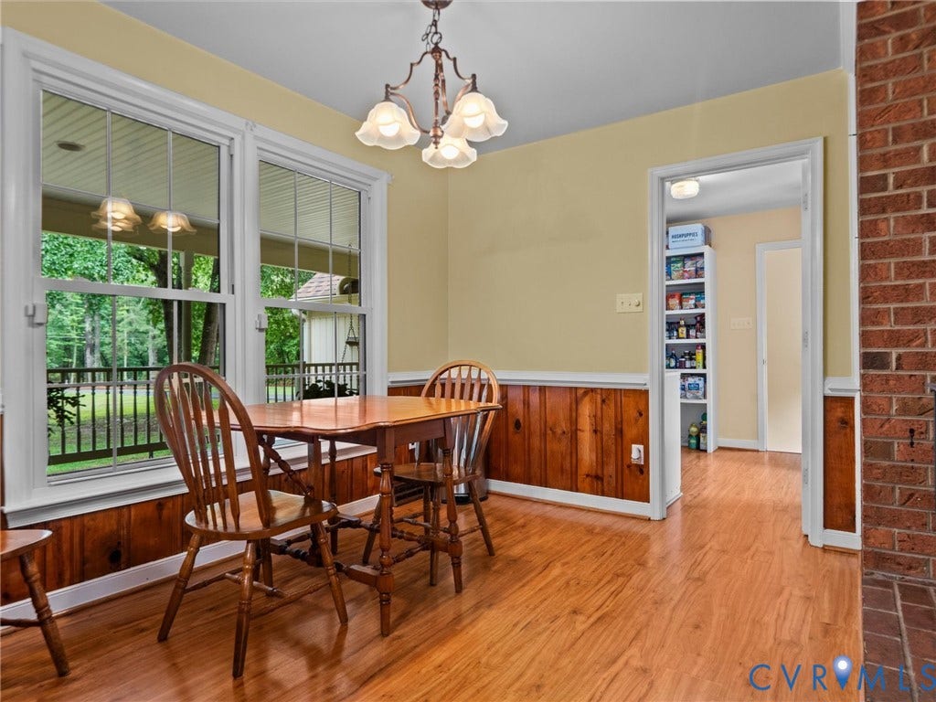 3420 Goodwyn Road, Powhatan, VA 23139 Dining area featuring wood-finish flooring, a decorative chandelier, and paneled wainscoting