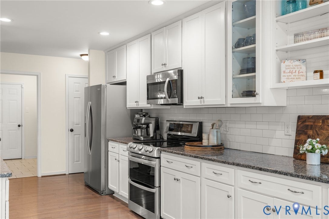 2803 Preston Park Way, Preston Park, Sandy Hook, VA 23153 Kitchen loaded with white cabinets, stainless steel appliances, granite counters, bar stool area, breakfast nook, pantry and wood floors.