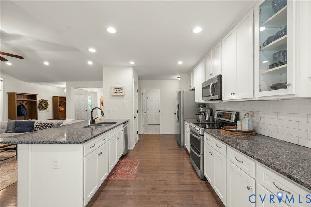 2803 Preston Park Way, Preston Park, Sandy Hook, VA 23153 Kitchen loaded with white cabinets, stainless steel appliances, granite counters, bar stool area, breakfast nook, pantry and wood floors.