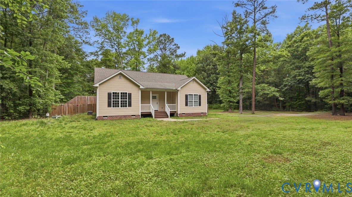 2406 Emanuel Church Road, Powhatan, VA 23139 Single-story residence featuring a covered front porch with white columns, light-colored siding, dark window shutters, and a wood privacy fence