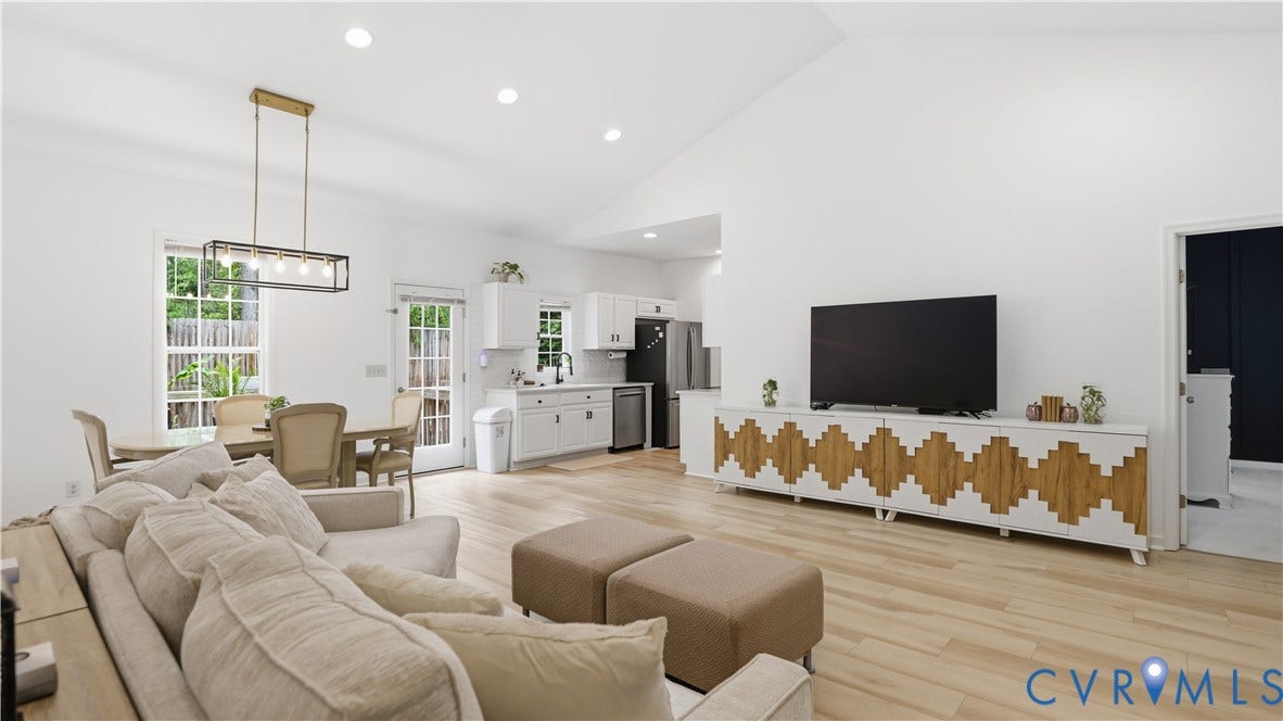 2406 Emanuel Church Road, Powhatan, VA 23139 Open-concept living area with vaulted ceilings, light wood-finish flooring, recessed lighting, and a modern kitchen featuring white cabinetry and stainless steel appliances