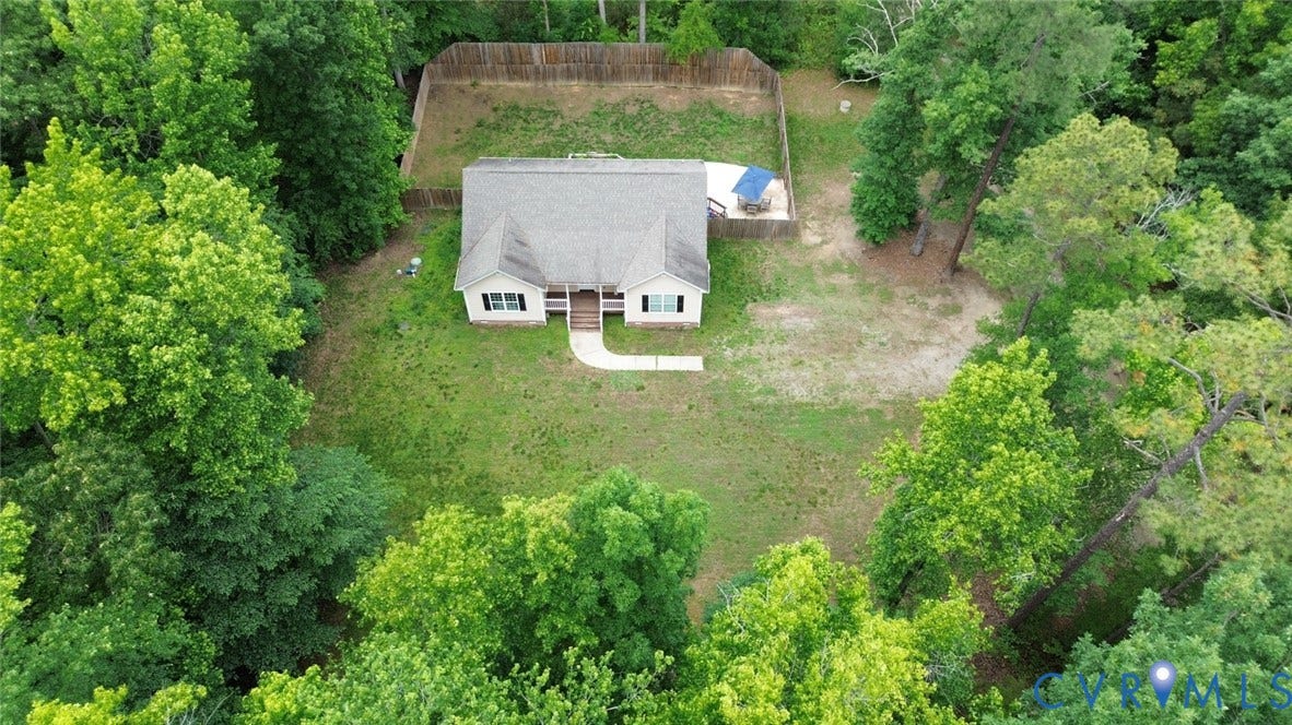 2406 Emanuel Church Road, Powhatan, VA 23139 Single-story residence surrounded by mature trees, featuring a light-toned exterior, a gray shingle roof, and a front porch with white railings