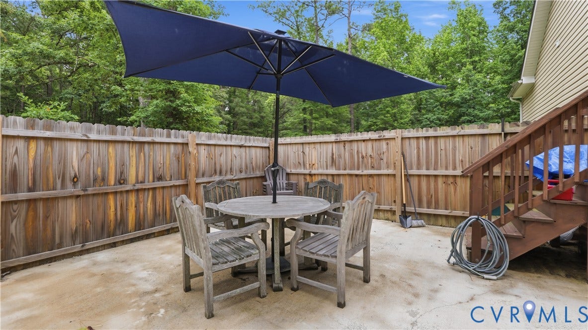 2406 Emanuel Church Road, Powhatan, VA 23139 Concrete patio area featuring a wooden privacy fence and a stained wood staircase