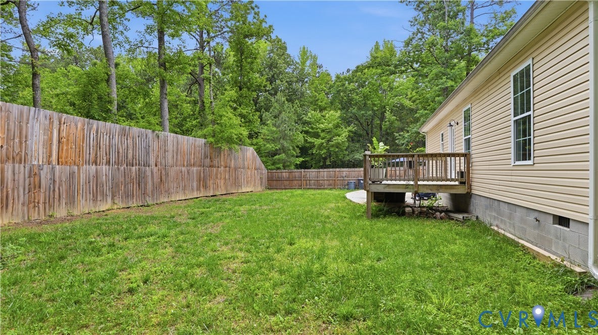 2406 Emanuel Church Road, Powhatan, VA 23139 Expansive backyard featuring a wood privacy fence, a wooden deck, and a concrete patio