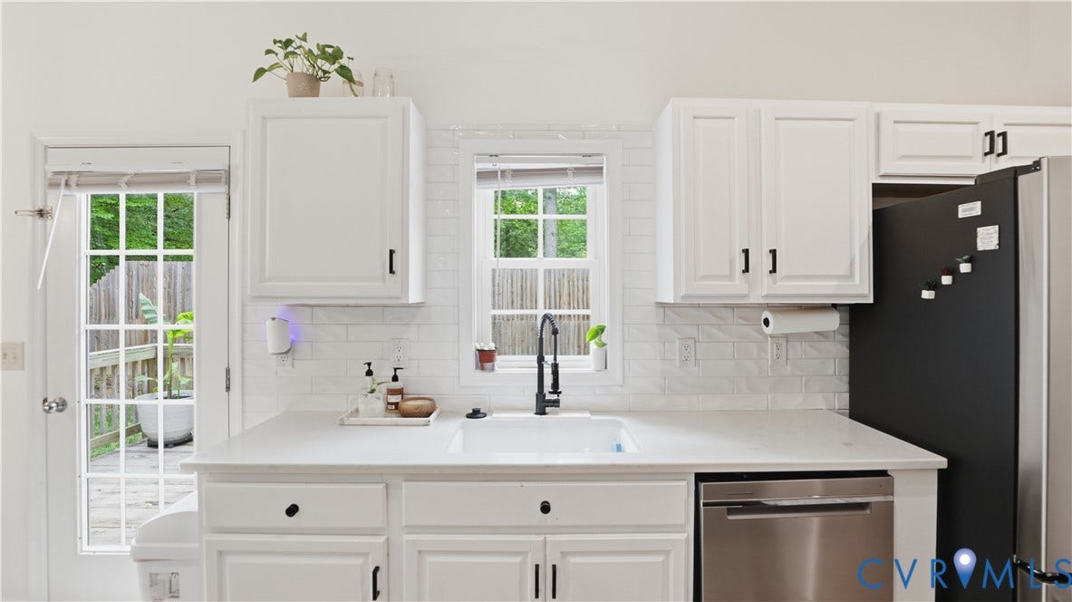 2406 Emanuel Church Road, Powhatan, VA 23139 Bright kitchen featuring white cabinetry, a single basin sink with a black faucet, white subway tile backsplash, stainless steel dishwasher, and a glass-paned door