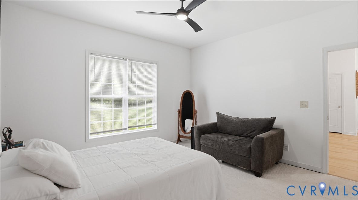2406 Emanuel Church Road, Powhatan, VA 23139 Bright interior space featuring a window with grid patterns, a modern black ceiling fan with integrated lighting, and light-colored carpeting