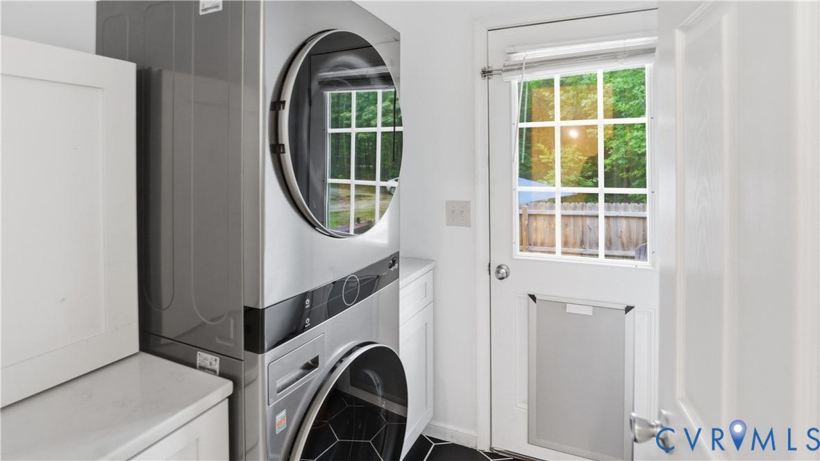 2406 Emanuel Church Road, Powhatan, VA 23139 Laundry area featuring a stacked washer and dryer unit, white cabinetry with a light-toned countertop, and black hexagonal floor tiles