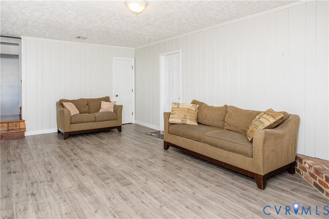 4512 Wraywood Avenue, Preston Place, Chester, VA 23831 Wood-finish plank flooring, white vertical wall paneling, and a textured ceiling