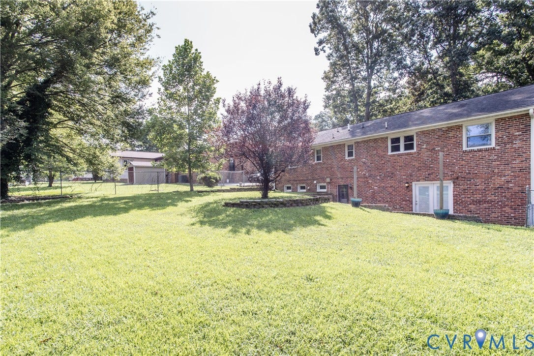 4512 Wraywood Avenue, Preston Place, Chester, VA 23831 Expansive lawn area with mature trees, brick exterior, and multiple ground-level entry points