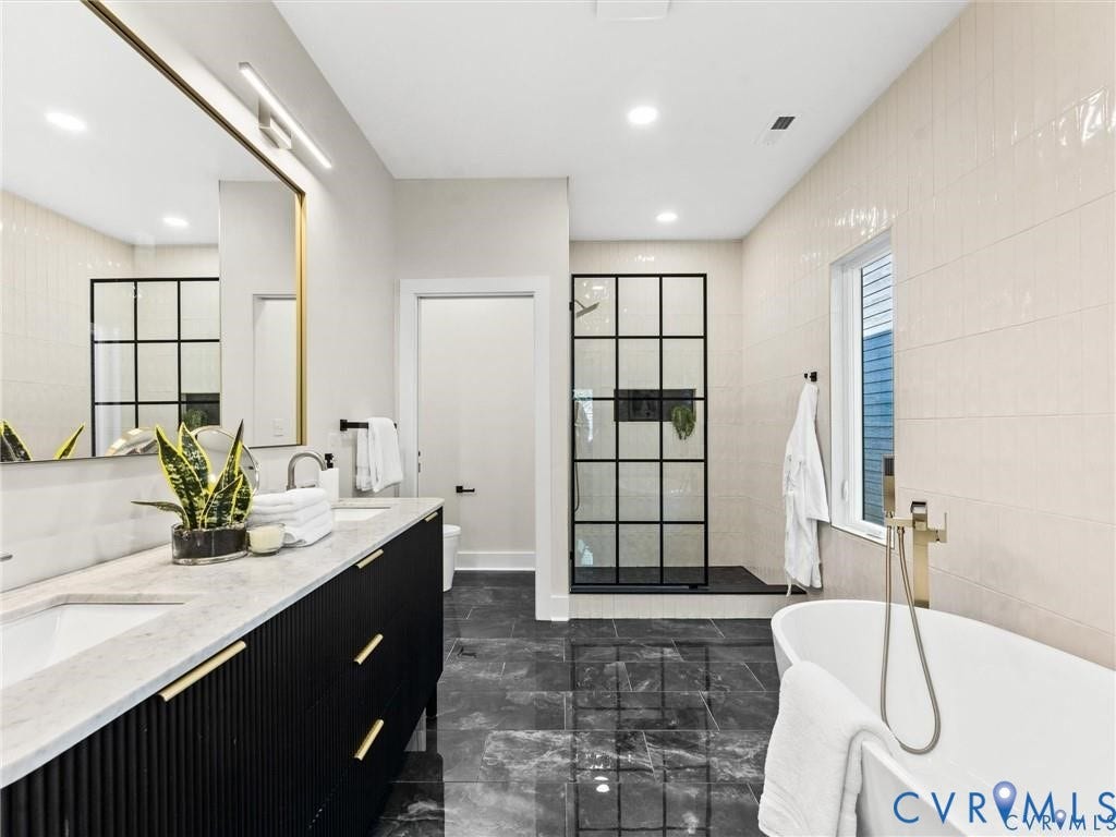 2200 3rd Avenue, Northside, Richmond, VA 23222 Ensuite bathroom with double vanity, recessed lighting, tile walls, a soaking tub, and dark marble finish floors