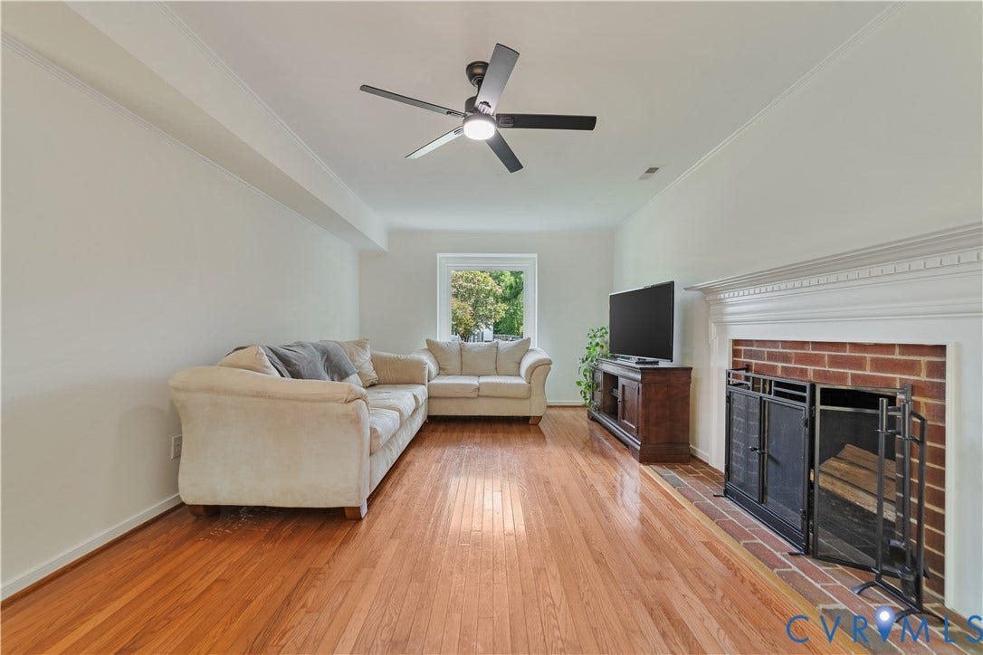 11060 Forest Trace Way, Forest Trace, Glen Allen, VA 23059 Hardwood flooring, a prominent brick fireplace with a white mantel, and a ceiling fan with integrated lighting