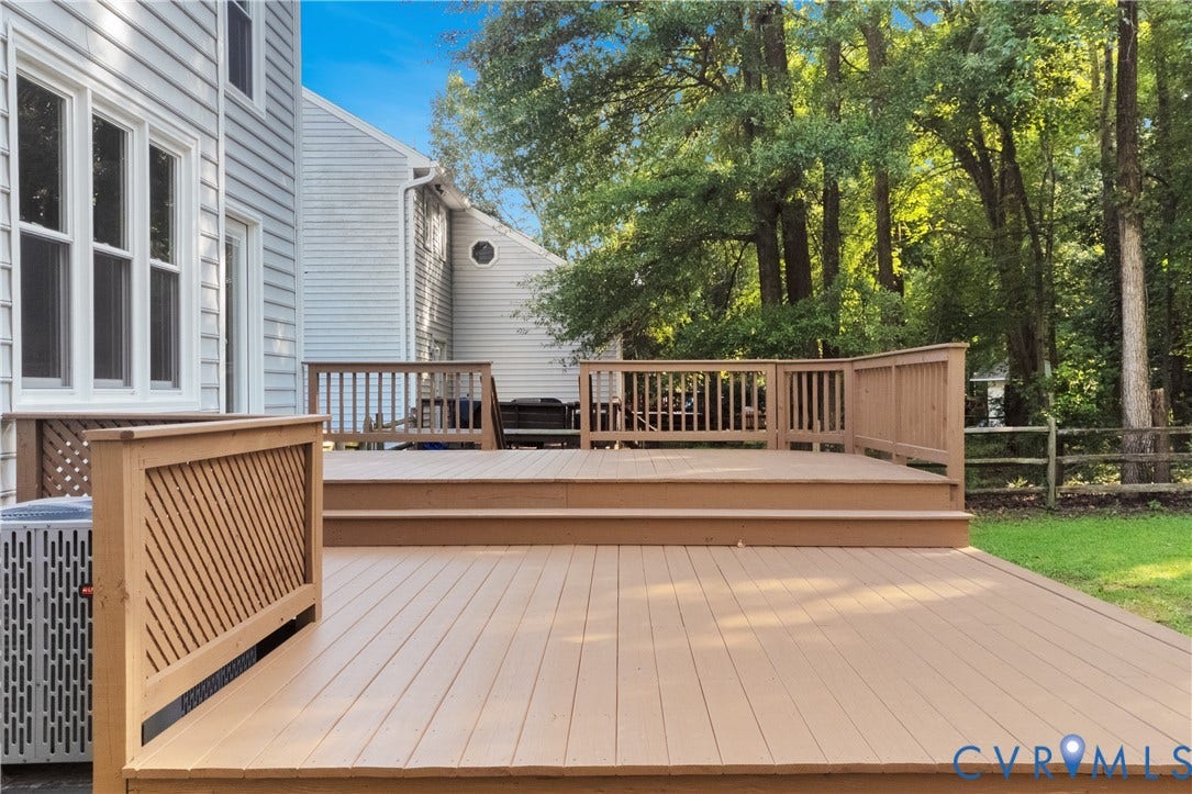 11060 Forest Trace Way, Forest Trace, Glen Allen, VA 23059 Two-tier outdoor deck with wood railing, set against a backdrop of mature trees and a fenced perimeter