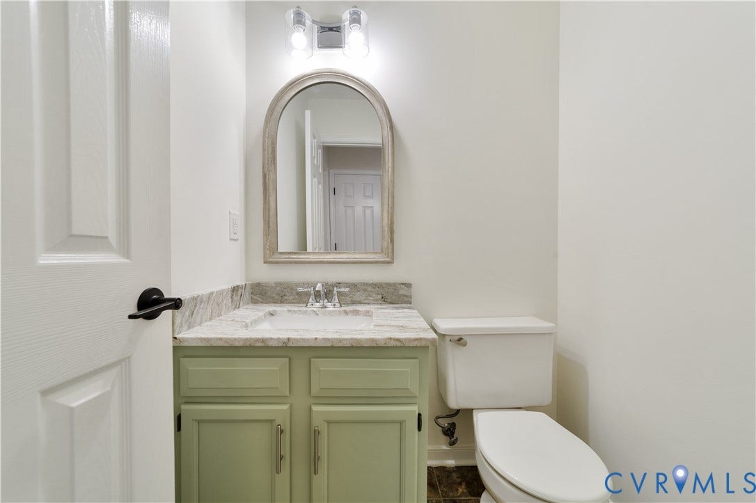 11060 Forest Trace Way, Forest Trace, Glen Allen, VA 23059 Light green vanity with an integrated sink, stone countertop, and arched mirror