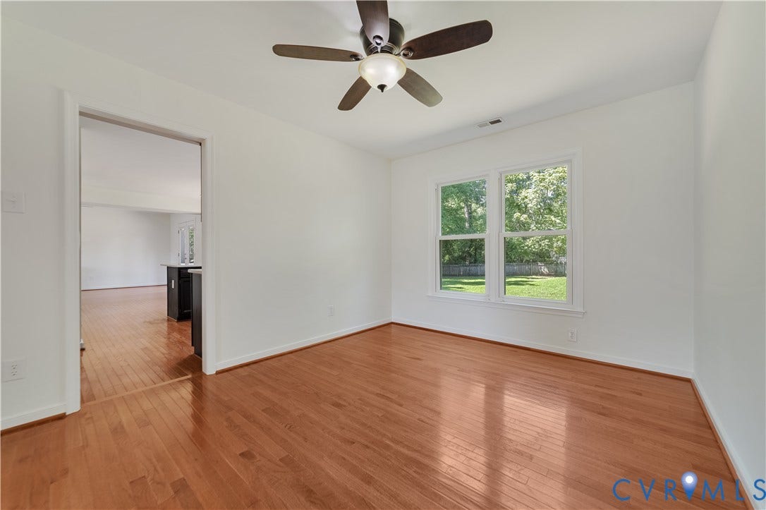 11060 Forest Trace Way, Forest Trace, Glen Allen, VA 23059 Hardwood flooring, white painted walls, ceiling-mounted fan with light fixture, and double pane windows overlooking a green yard