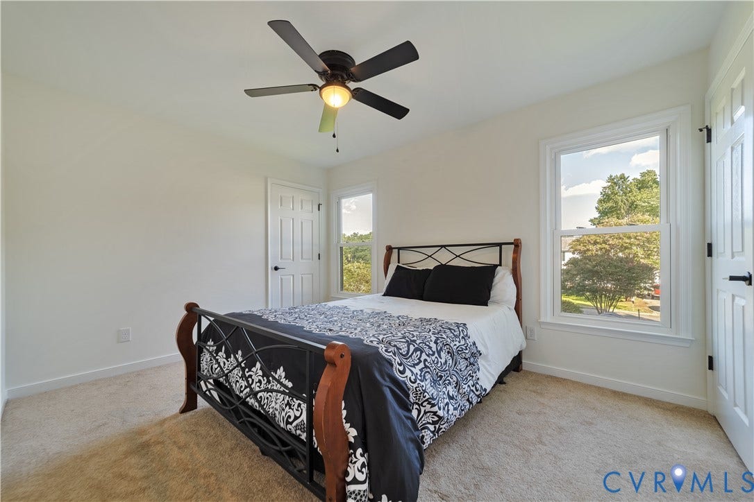 11060 Forest Trace Way, Forest Trace, Glen Allen, VA 23059 Bright secondary bedroom featuring a ceiling fan with integrated lighting, carpet flooring, and large glass doors opening to outdoor scenery