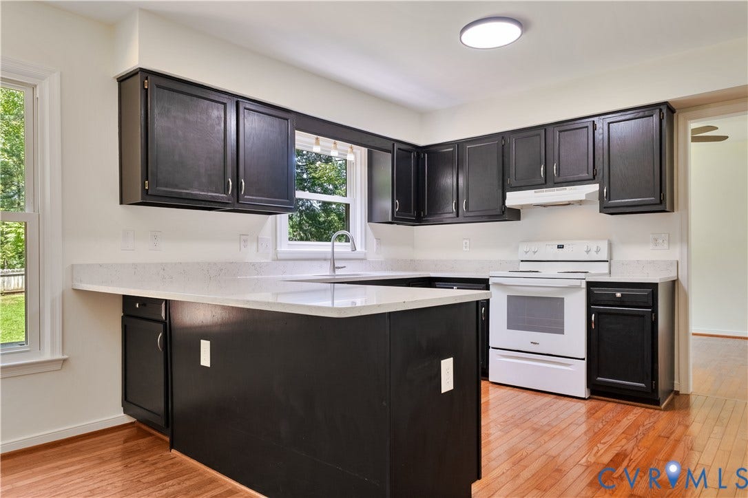 11060 Forest Trace Way, Forest Trace, Glen Allen, VA 23059 Kitchen featuring a U-shaped layout, dark wood cabinetry, light-toned countertops, hardwood flooring, and a window above the sink