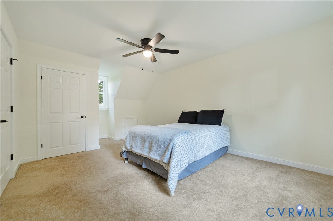 11060 Forest Trace Way, Forest Trace, Glen Allen, VA 23059 Carpeted room featuring a ceiling fan, white paneled doors with black hardware, an angled ceiling, and a window with white trim