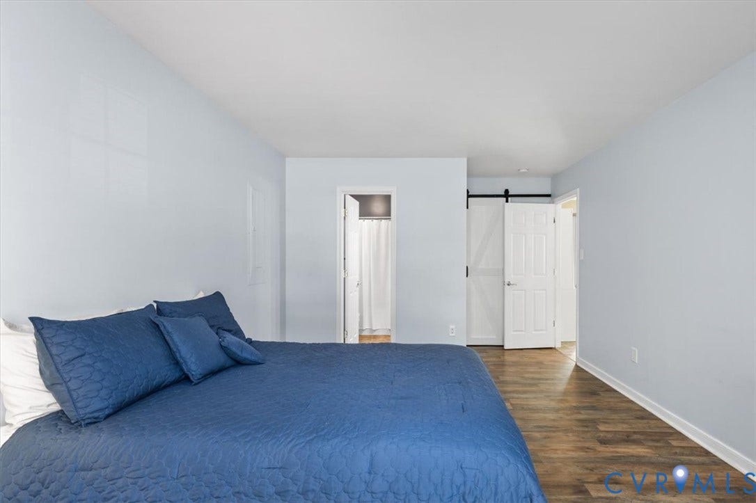 1st Floor Primary Ensuite with attached bath and walk in closet behind the barn door.