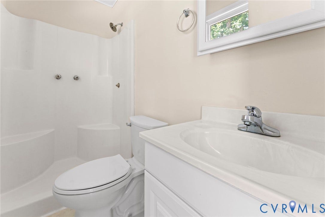 3020 Sand Hills Drive, Chester, VA 23831 Bathroom featuring a white integrated sink vanity, chrome faucet, and a one-piece shower surround with a built-in seat