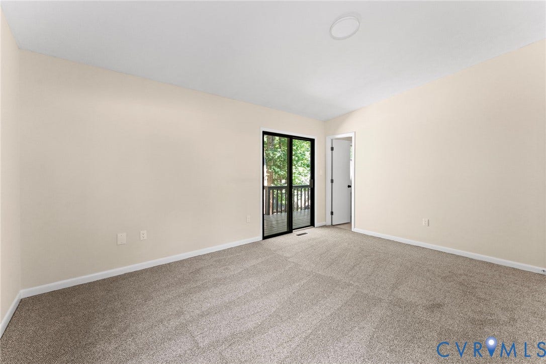 3020 Sand Hills Drive, Chester, VA 23831 Spacious room featuring neutral carpeting, light-toned walls, and a sliding glass door providing direct access to an exterior deck
