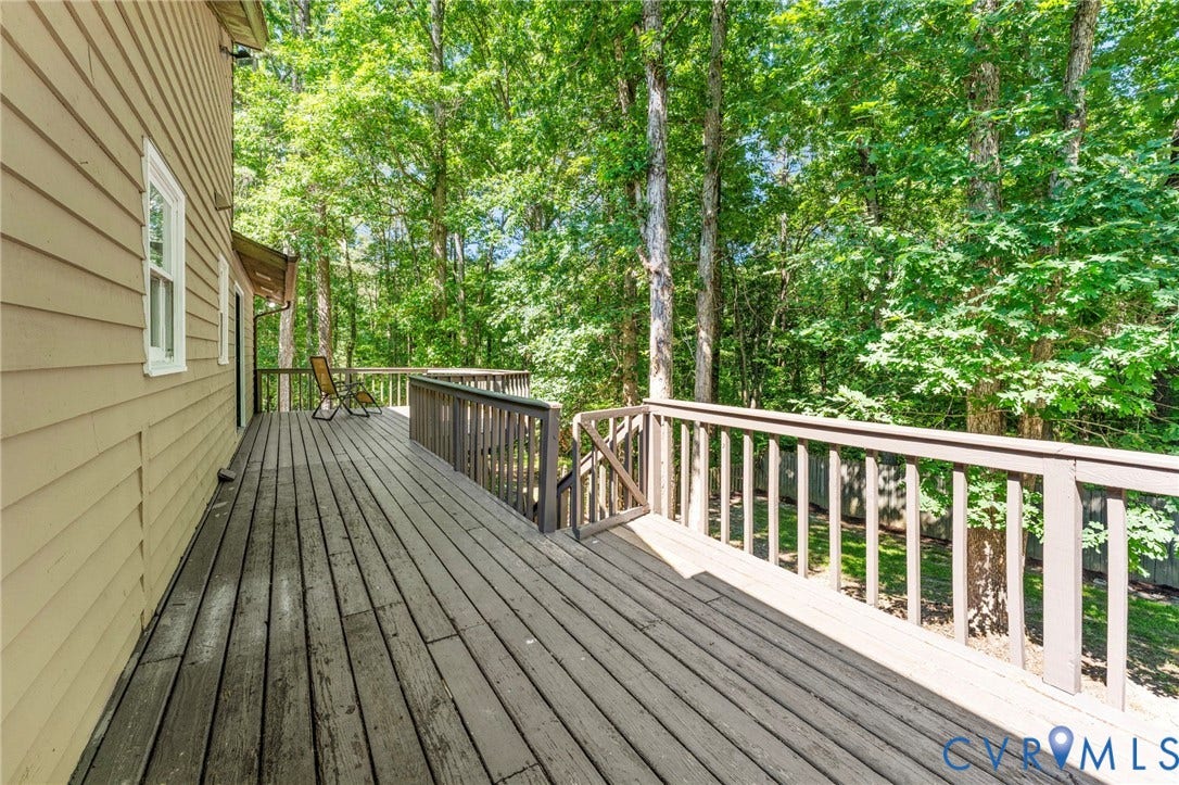 3020 Sand Hills Drive, Chester, VA 23831 Expansive outdoor decking with a slatted railing system and a backdrop of mature trees