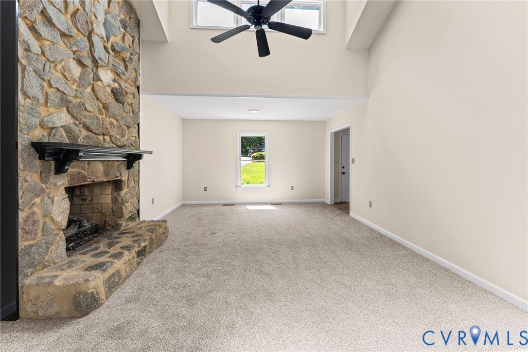 3020 Sand Hills Drive, Chester, VA 23831 Great room featuring a floor-to-ceiling stone fireplace with a dark wood mantel, vaulted ceilings, a ceiling fan, and light-toned carpeting