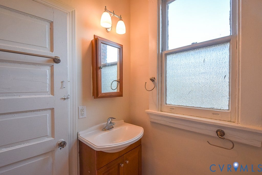 120 S Arthur Ashe Boulevard, #1, Richmond, VA 23220 Bathroom vanity with a white ceramic sink, wood-finish cabinet, and a mirrored medicine cabinet